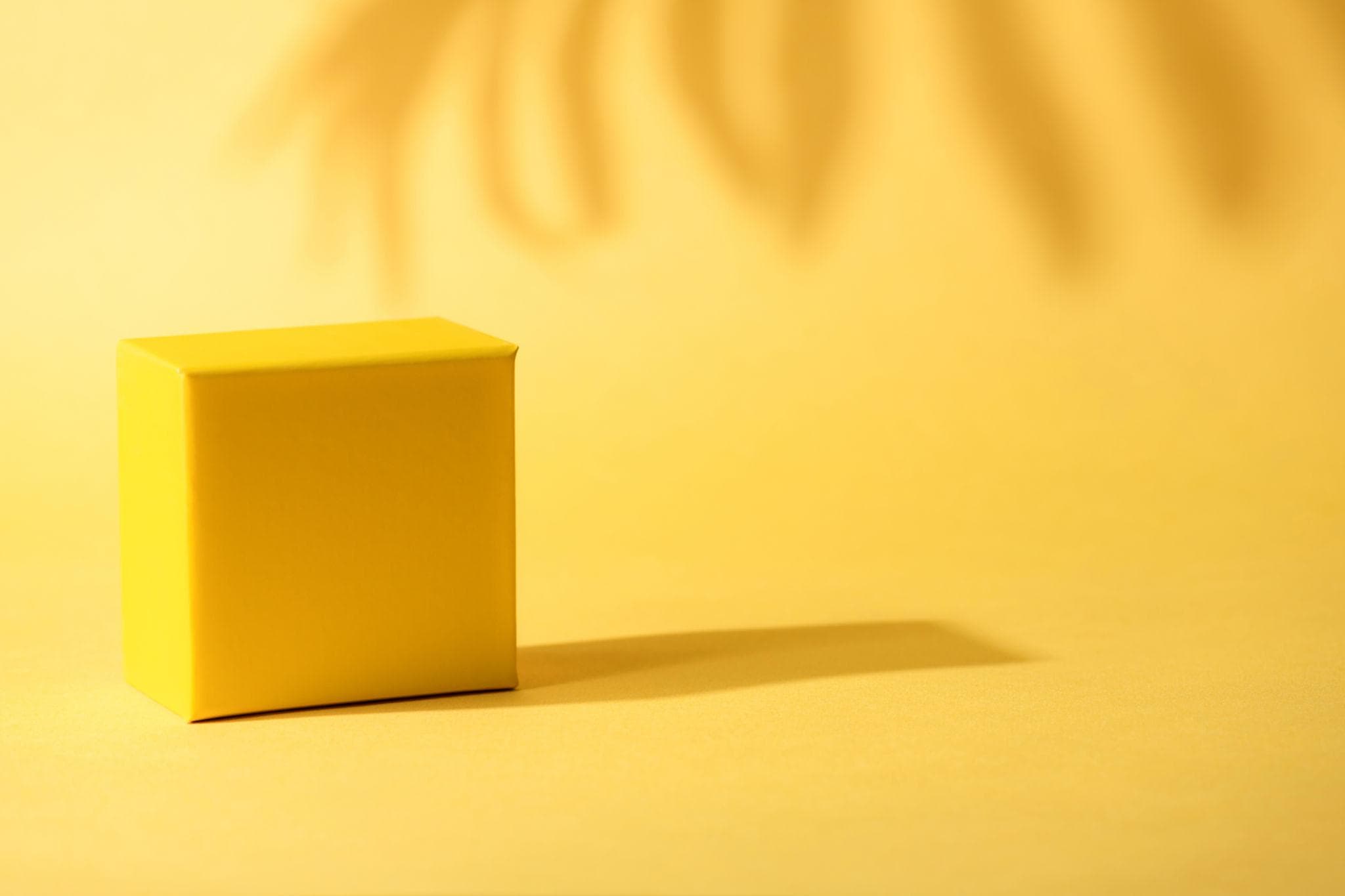 Composicion de marca con fondo amarillo y cubo