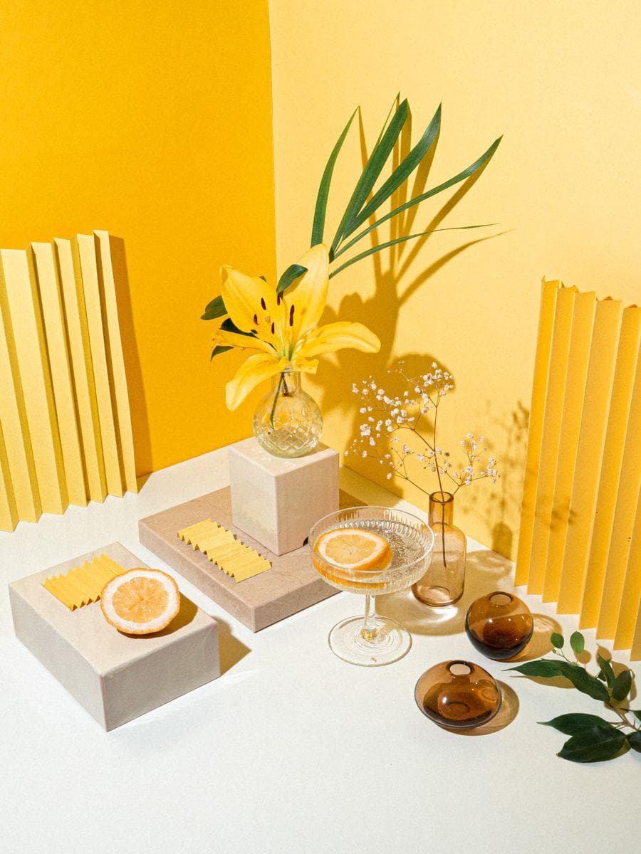 Bodegon floral con citricos sobre fondo amarillo